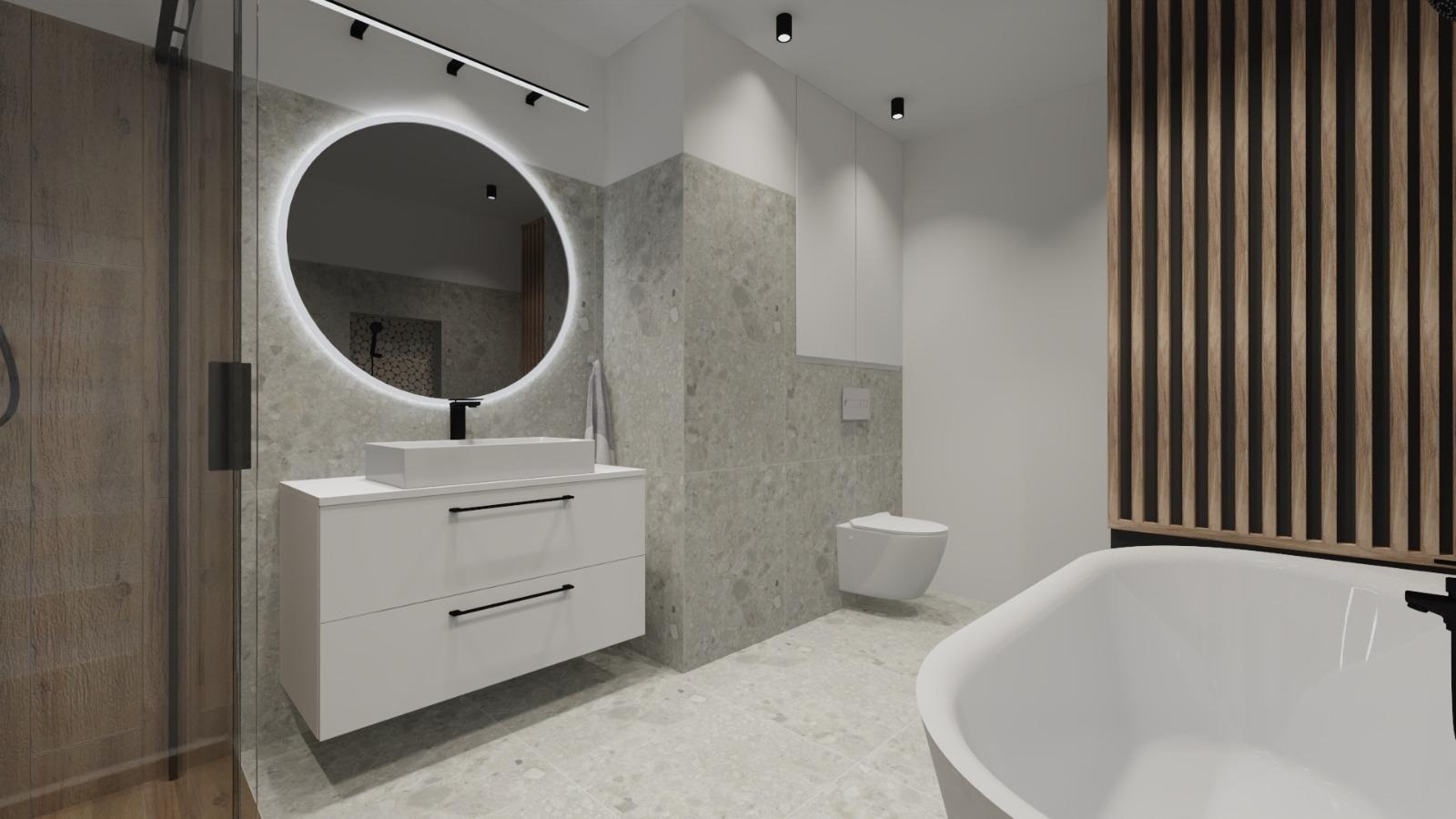 Nowoczesna łazienka z okrągłym lustrem LED, białą szafką pod umywalką, wanną i drewnianymi lamelami dekoracyjnymi. Szaro-beżowa kolorystyka płytek.