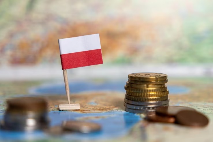 Polska flaga wbita obok stosu złotych monet na mapie. Symbol finansów w Polsce, może dotyczyć podatków, księgowości lub biznes planu.