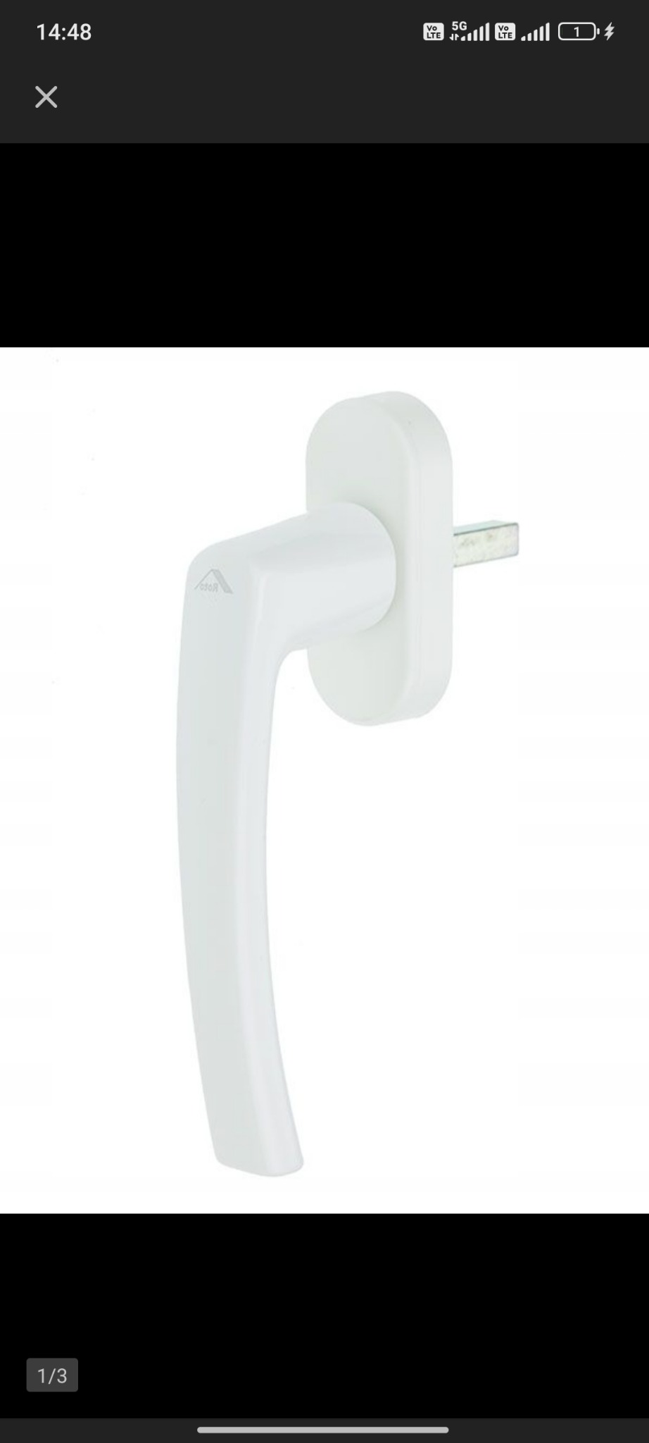 Biała klamka okienna z widocznym trzpieniem, prezentowana na jasnym tle. Detal okucia okiennego, element systemu zamykania okna.