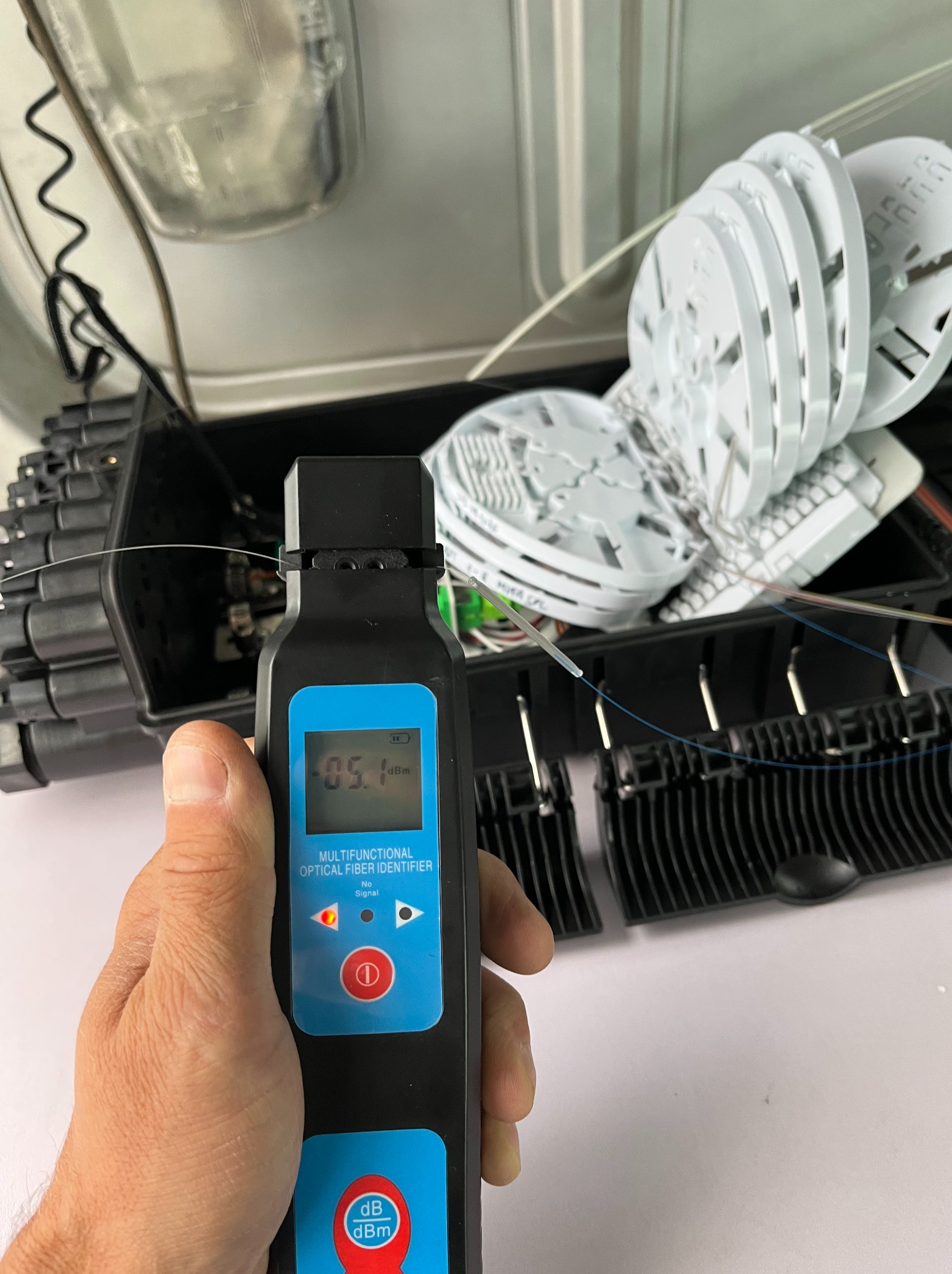 Pomiar światłowodu identyfikatorem mocy optycznej w skrzynce telekomunikacyjnej. Sprawdzanie sygnału światłowodowego podczas instalacji.