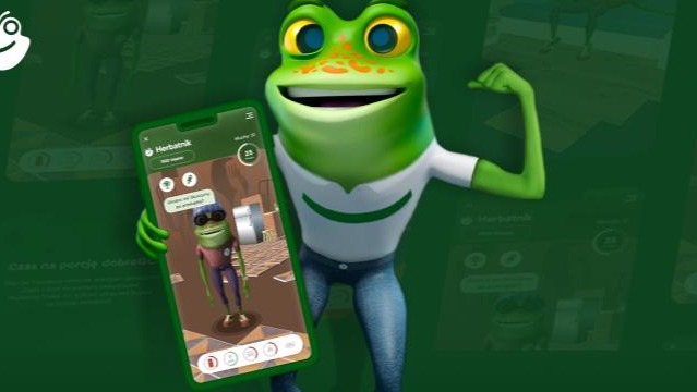 Grafika 3D żaby z aplikacją 'Herbatnik' na smartfonie, w kolorystyce zieleni, na tle zielonego gradientu. Projekt reklamowy dla klienta z Mierzyna.