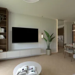 Salon z telewizorem, regałem na książki i rośliną doniczkową. W tle widoczna kuchnia z barkiem i krzesłami. Nowoczesne oświetlenie i parkiet w jodełkę.