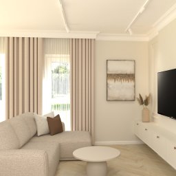 Jasny salon z beżową sofą narożną, okrągłym stolikiem kawowym i telewizorem na ścianie. Neutralna kolorystyka, minimalistyczny design, subtelne oświetlenie punktowe.