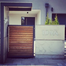 Słupek wejściowy z zadaszeniem oraz numerem posesji. Płyty betonowe. Konstrukcja stalowa bądź aluminiowa.