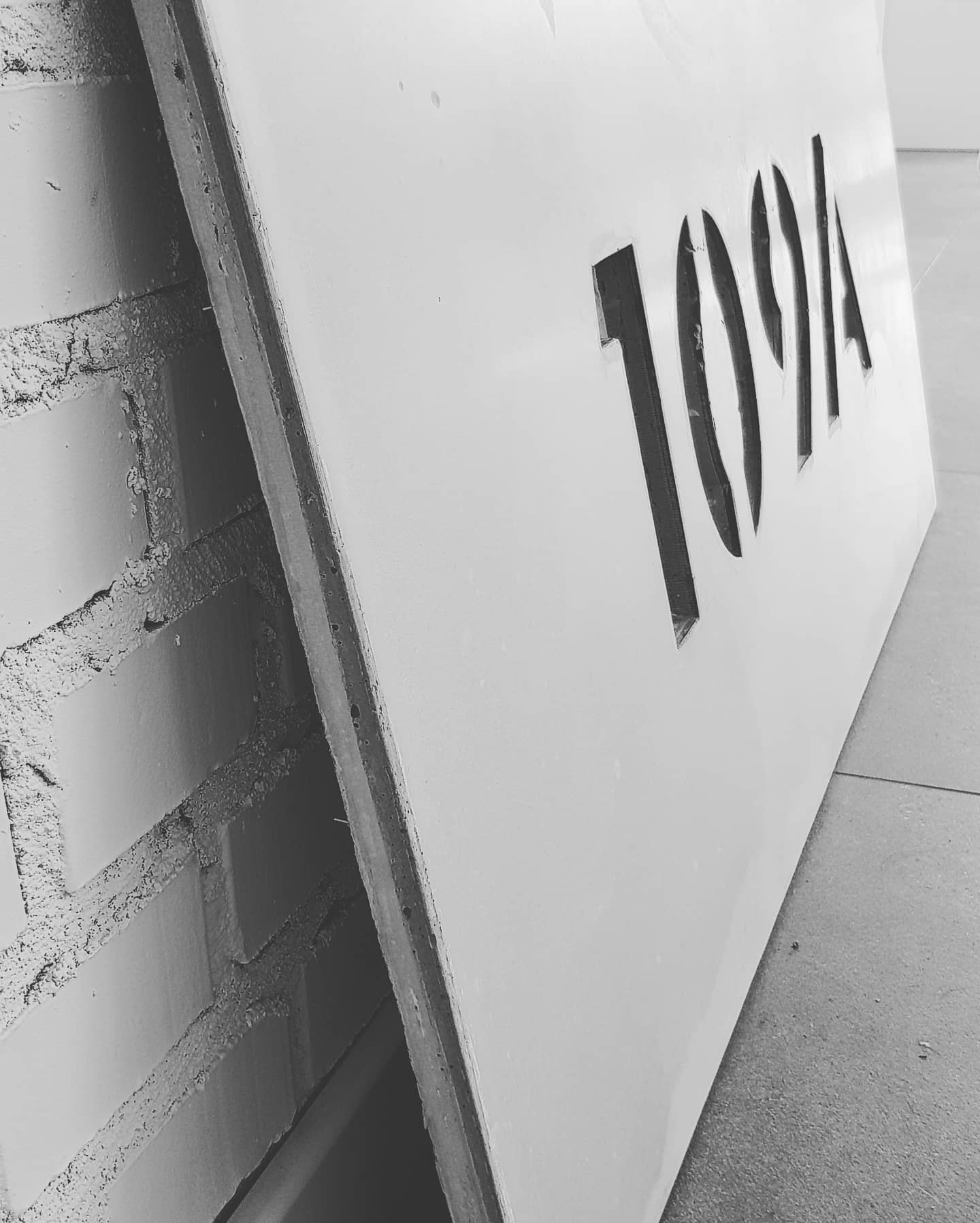 Płyta betonowa z numerem posesji.