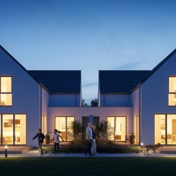 vizualemotion.pl-Iwanowicz Adam - Nowoczesny dom dwurodzinny oświetlony nocą, z rodziną i psem na zewnątrz. Minimalistyczna architektura, duże okna, ciepłe światło wewnątrz.