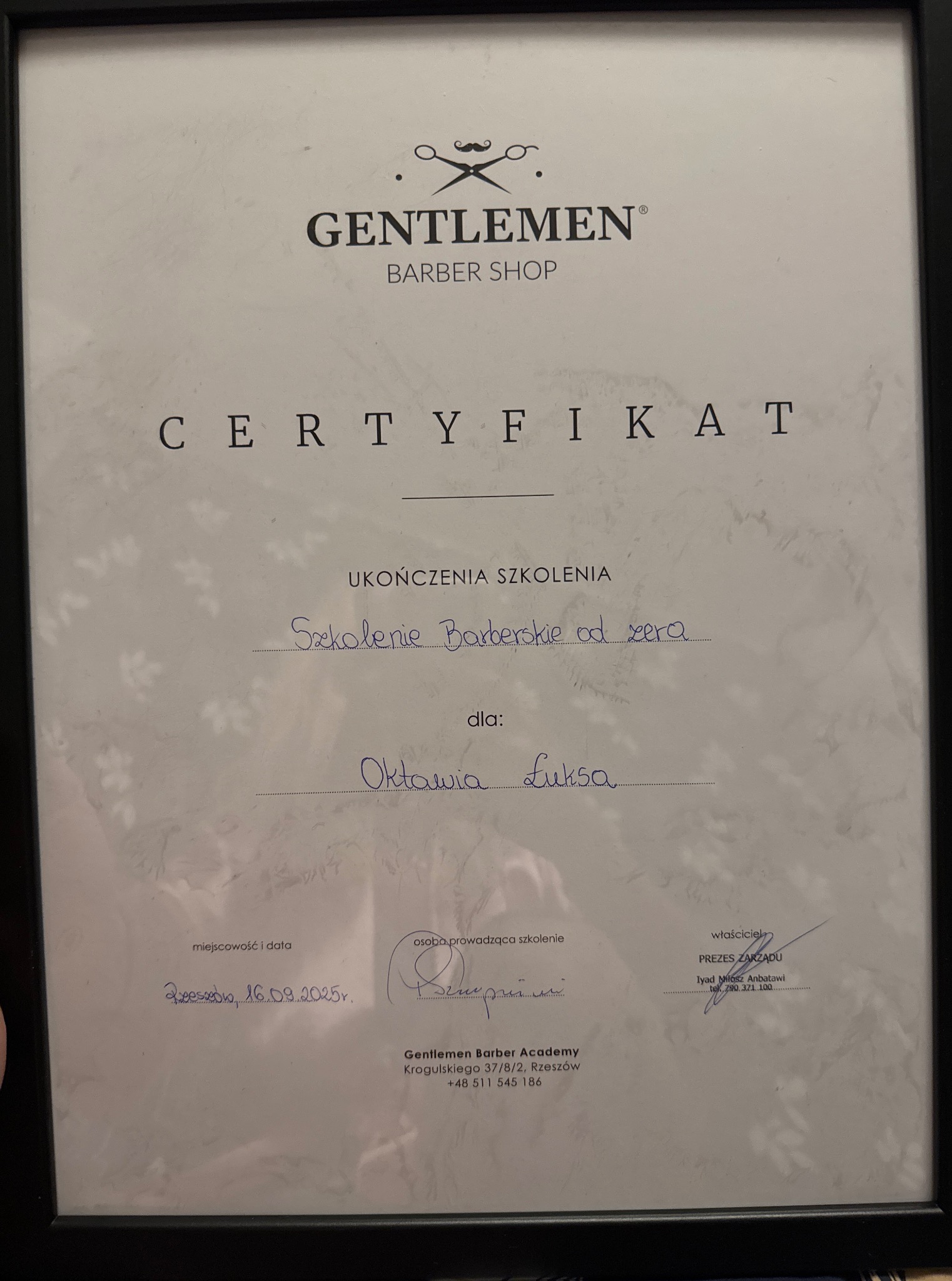 Certyfikat ukończenia szkolenia barberskiego 'Gentlemen Barber Shop' dla Oktawii Łuksa, oprawiony w ramkę. Data wystawienia: Rzeszów, 16.09.2025.