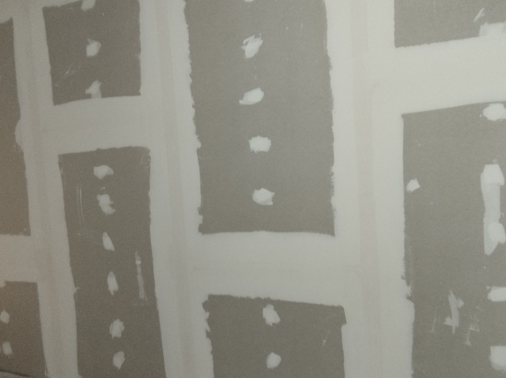 Szpachlowana ściana z płyt karton-gips w trakcie prac wykończeniowych w Warszawie. Widoczne łączenia płyt i miejsca po wkrętach.