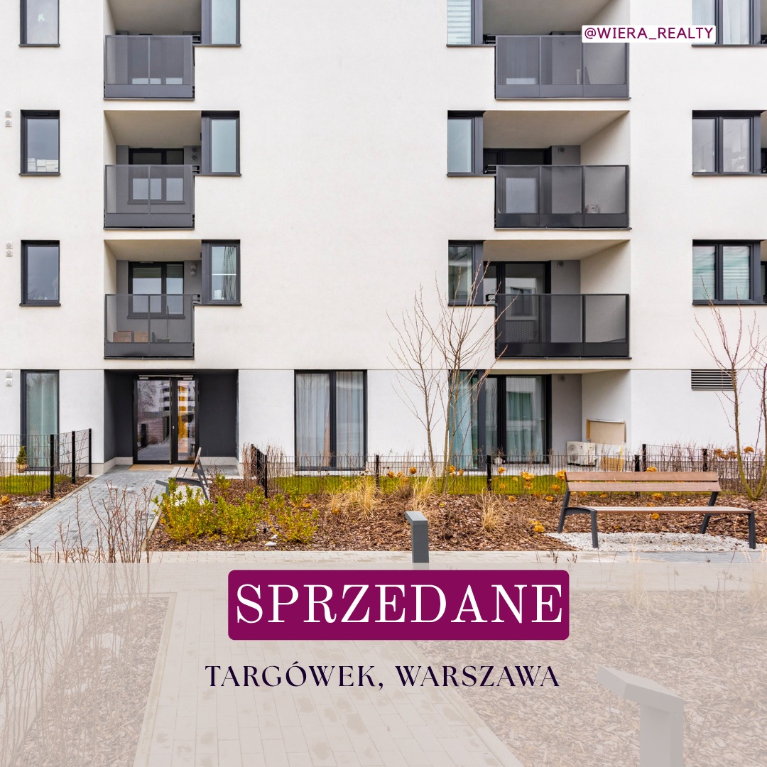Nowoczesny budynek mieszkalny z balkonami, oznaczony jako 'Sprzedane' na Targówku w Warszawie. Minimalistyczna architektura, ławka i zieleń przed budynkiem.