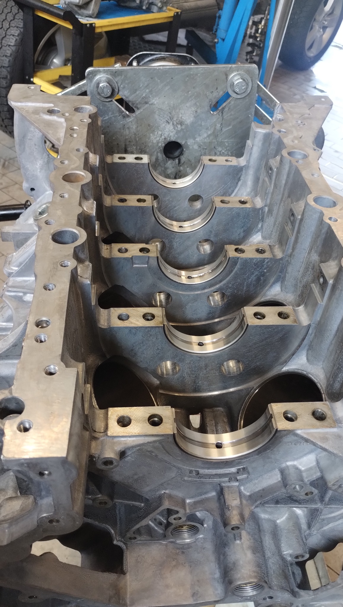 Otwarty blok silnika samochodowego z widocznymi panewkami i otworami montażowymi, ukazujący precyzję obróbki i przygotowanie do montażu.