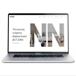 GWDesign Grzegorz Wieliczko - Ekran laptopa MacBook Pro prezentuje stronę internetową firmy architektonicznej z minimalistycznym designem wnętrz i hasłem 'Tworzymy wnętrza dopasowane do Ciebie'.