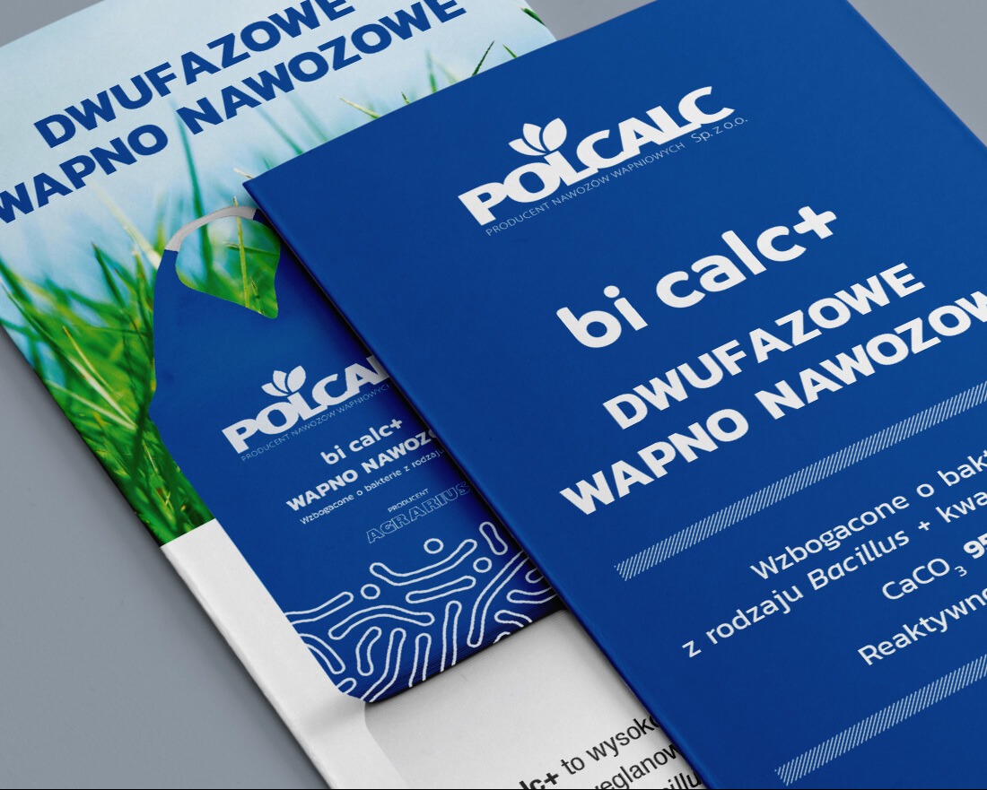 Dwa niebieskie foldery reklamowe Polcalc z nazwą produktu 'bi calc+' i informacjami o wapnie nawozowym, leżące ukośnie na szarym tle.