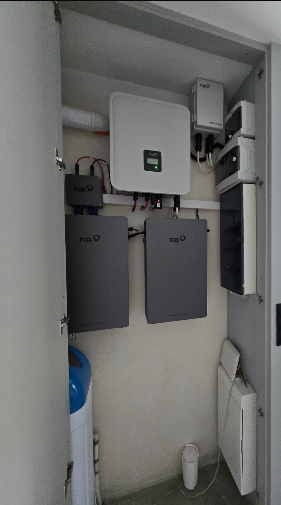 Wnętrze szafy z zainstalowanym magazynem energii FoxESS, widoczne akumulatory, inwerter i osprzęt. Kompaktowa instalacja w pomieszczeniu gospodarczym.