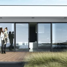 RAVEN S.C. KRZYSZTOF BOŚKA, SŁAWOMIR BŁASZCZAK - Eleganckie, szklane drzwi przesuwne z widokiem na morze. Kobieta z dzieckiem na tarasie z drewnianą podłogą. Minimalistyczny design i naturalne światło.