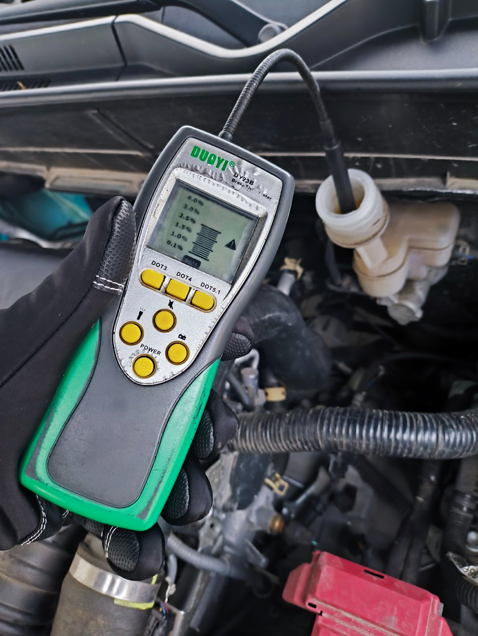 Pomiar zawartości wody w płynie hamulcowym testerem DUOYI DY23B, w zbiorniczku wyrównawczym, w komorze silnika. Diagnostyka płynu hamulcowego w warsztacie.