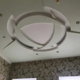 Oryginalny sufit podwieszany z gips-kartonu z oświetleniem punktowym w kształcie okręgu, Wrocław. Nowoczesne wykończenie wnętrza z dekoracyjną ścianą.