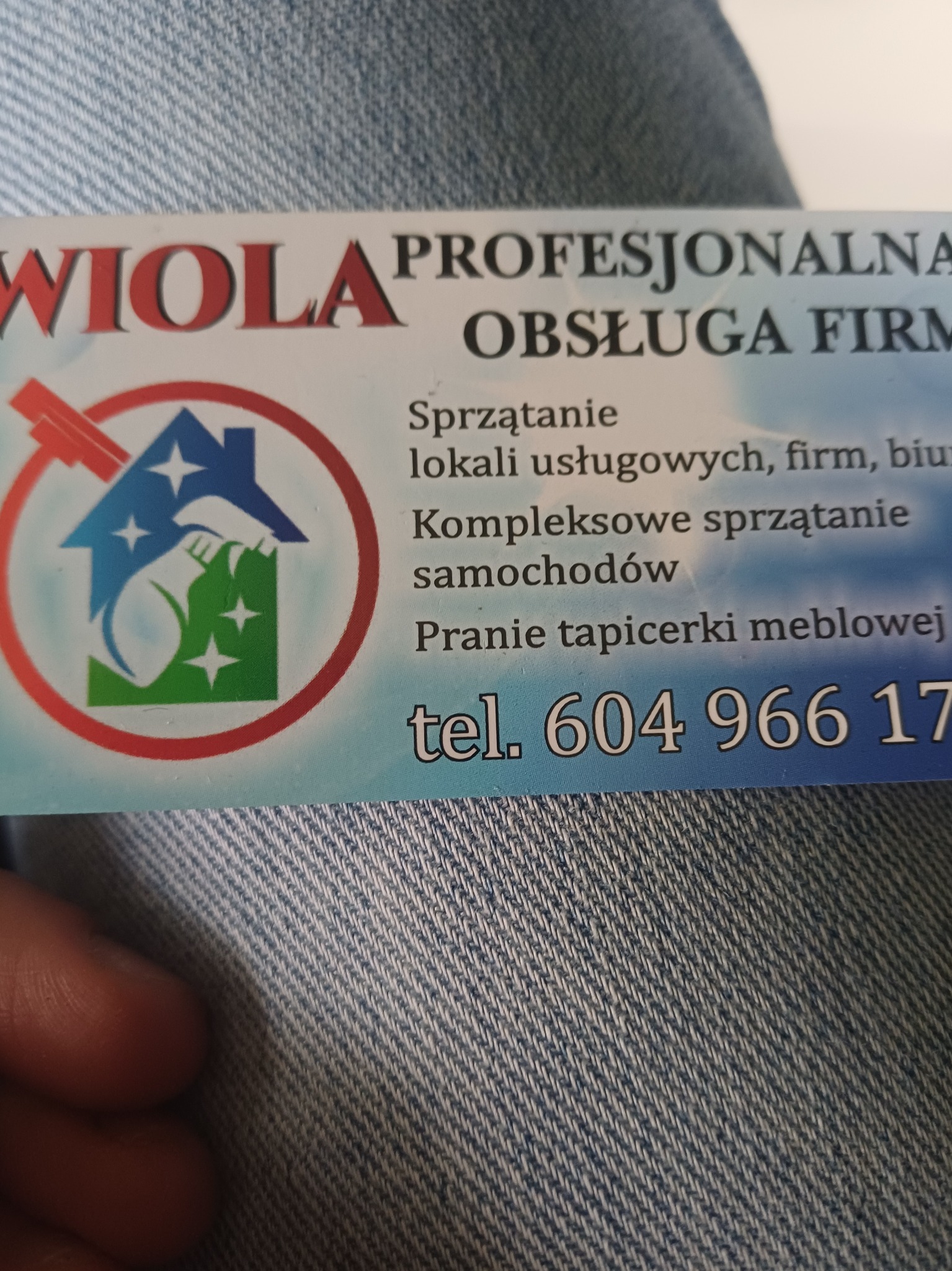 Wizytówka firmy sprzątającej 'Wiola' z ofertą sprzątania lokali, biur, samochodów i prania tapicerki meblowej. Numer telefonu widoczny.