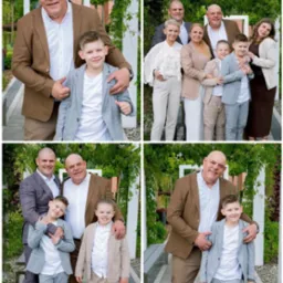 Uśmiechnięta rodzina w eleganckich strojach pozuje na tle zieleni. Mężczyźni w garniturach, chłopcy w marynarkach, kobiety w sukienkach i bluzkach. Radosna atmosfera.