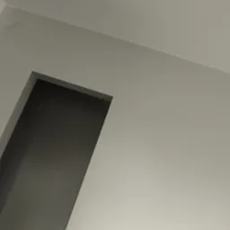 Wnętrze po malowaniu na szaro: gładkie ściany, otwór drzwiowy bez ościeżnicy, widoczne przewody elektryczne, przygotowane do dalszych prac wykończeniowych.