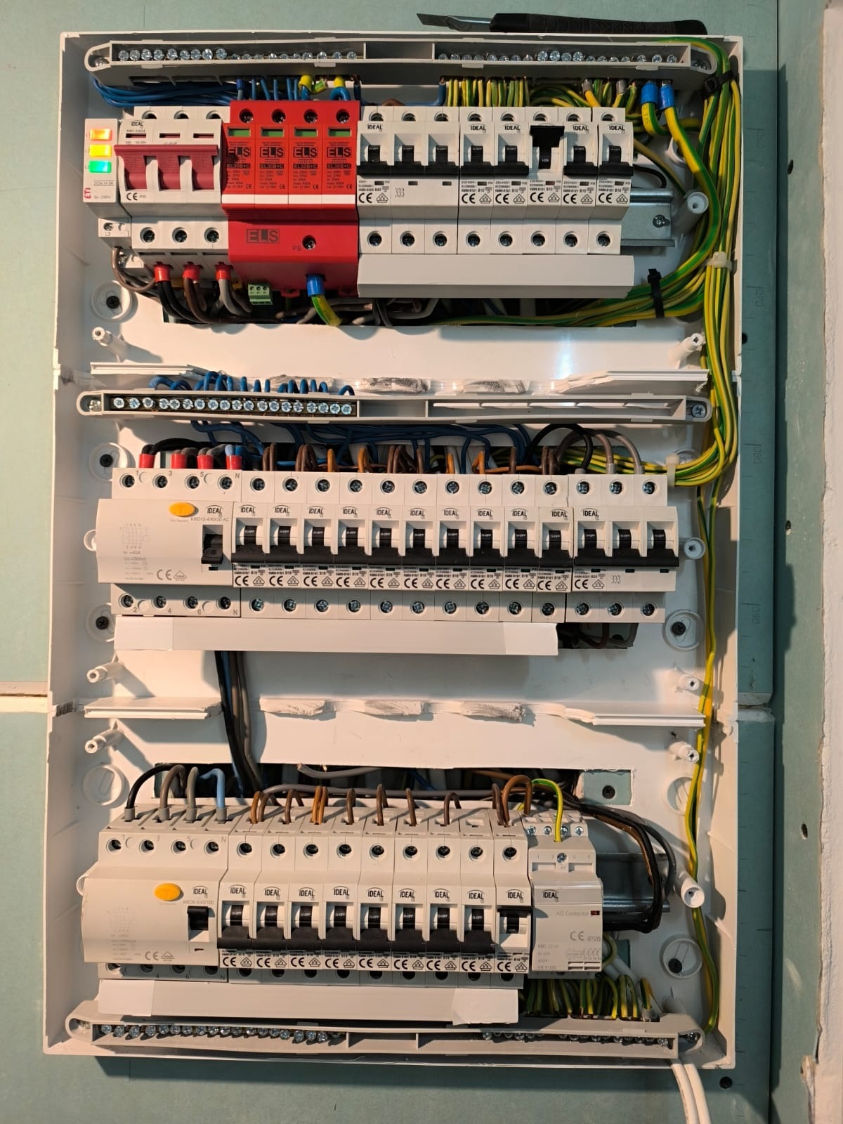 Rozdzielnica elektryczna z zabezpieczeniami i przewodami w Chorzowie. Widoczne bezpieczniki, ograniczniki przepięć i listwy zaciskowe. Estetyczne ułożenie przewodów.