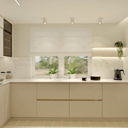 Design Atelier by Maria Słodowska - Elegancka kuchnia w beżach z marmurowym blatem i frontami z poziomymi uchwytami. Na blacie czajnik, ciasto i doniczki z kwiatami, a w tle okno z roletą rzymską.
