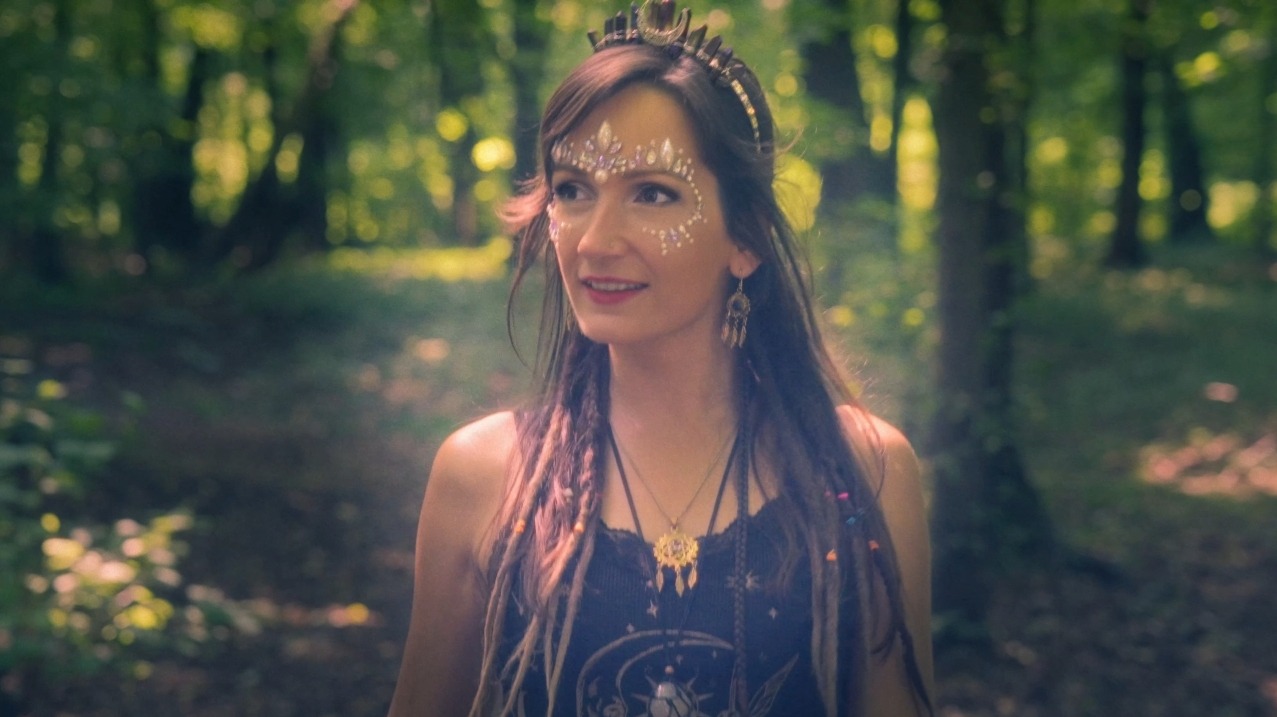 Kobieta z artystycznym makijażem i ozdobną koroną na tle leśnej scenerii. Uwagę przykuwają detale makijażu i biżuterii, tworzące magiczny, eventowy klimat.