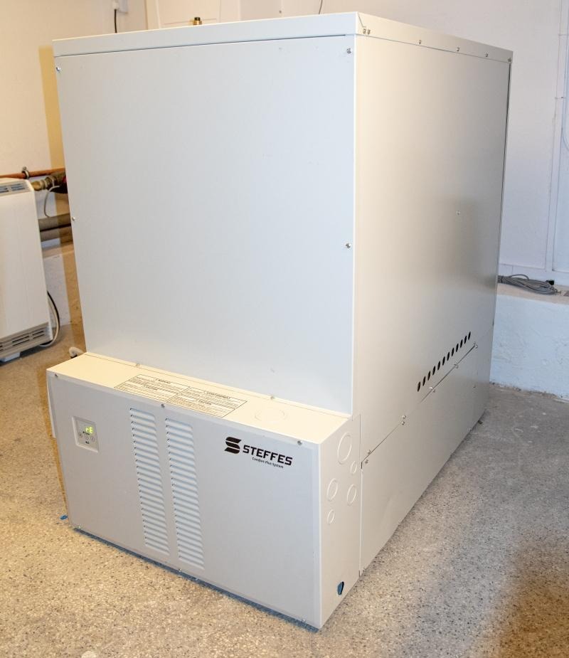 Biały, prostopadłościenny akumulacyjny piec elektryczny marki Steffes, z widocznymi otworami wentylacyjnymi i etykietami informacyjnymi, umieszczony w pomieszczeniu.