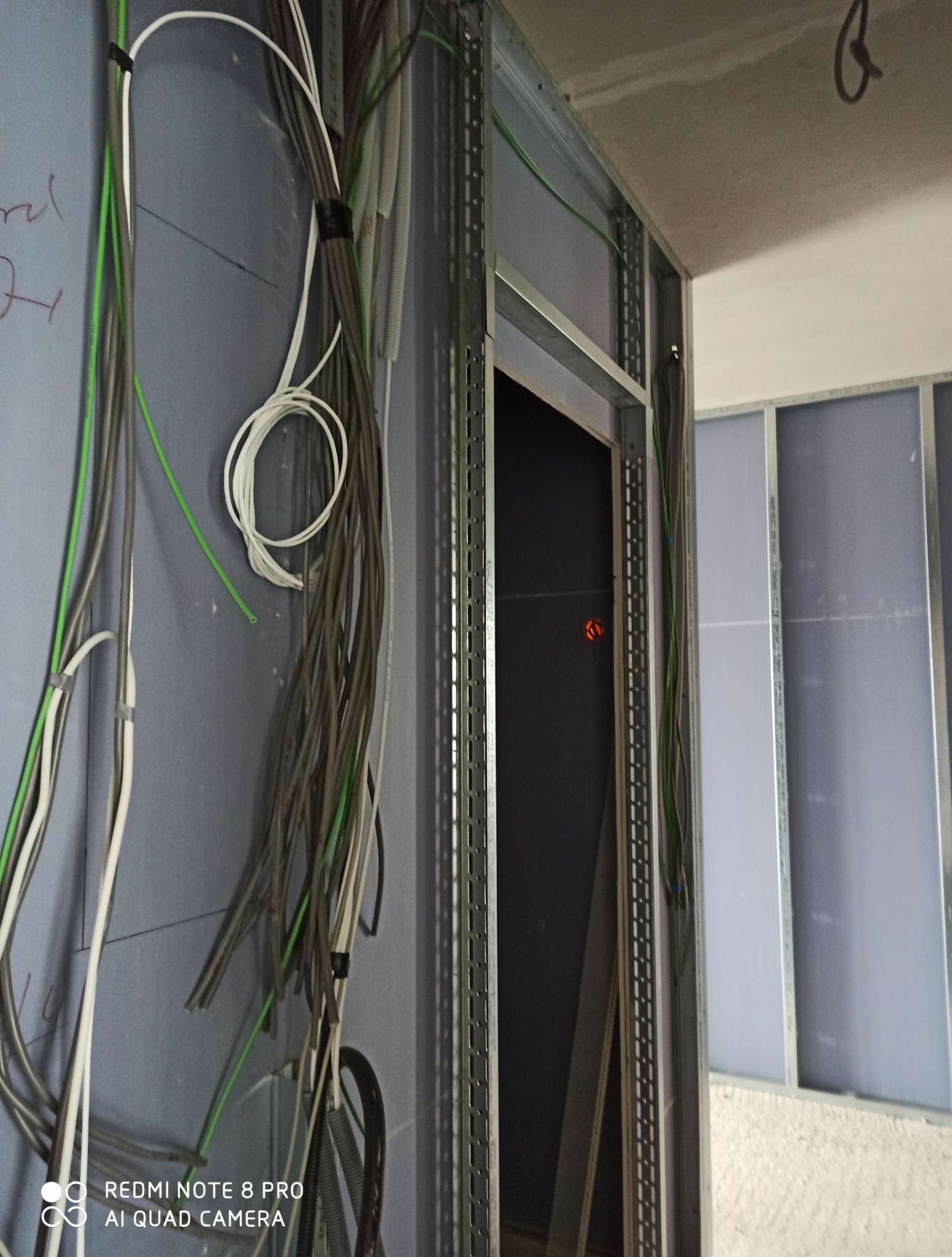 Montaż instalacji elektrycznej i konstrukcji z płyt gipsowo-kartonowych. Widoczne przewody i metalowe profile. Etap prac wykończeniowych.