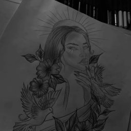 Weronika Skwara - Szkic ołówkiem: portret kobiety z kwiatami i gołębiami na papierze, otoczony przyborami do rysowania w czerni i bieli. Widok z góry.