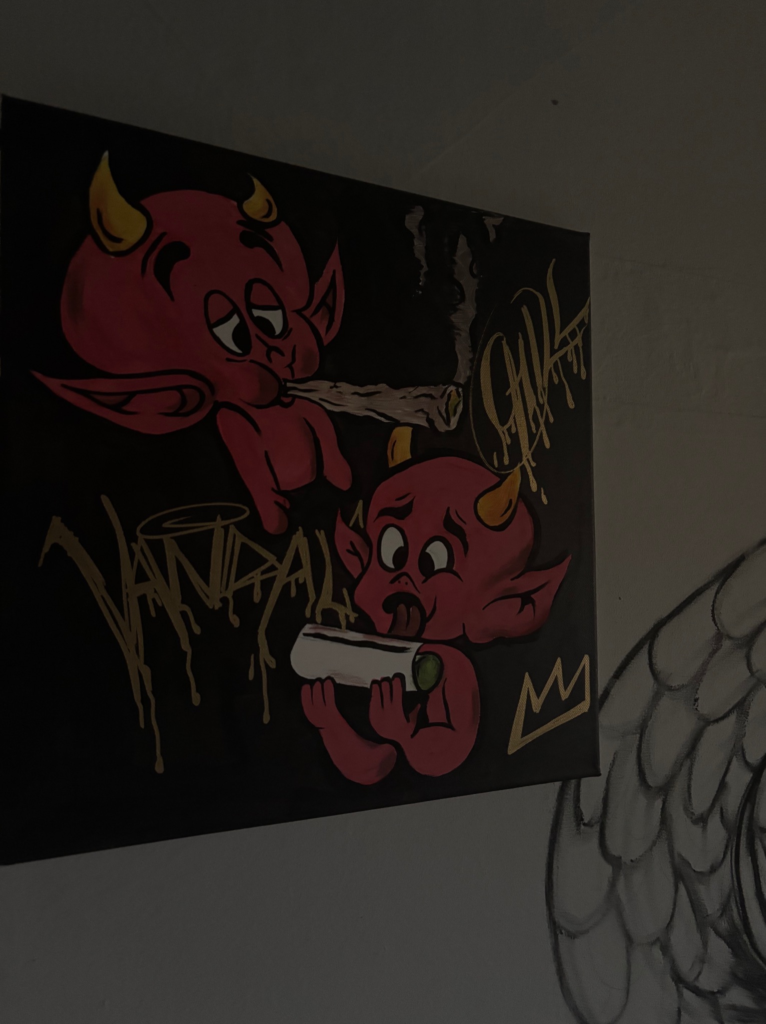 Mroczny obraz na płótnie: dwa czerwone diabełki, jeden pali jointa, drugi go skręca. Napis 'VANDAL' i korona w złotych barwach. Część graffiti na ścianie.