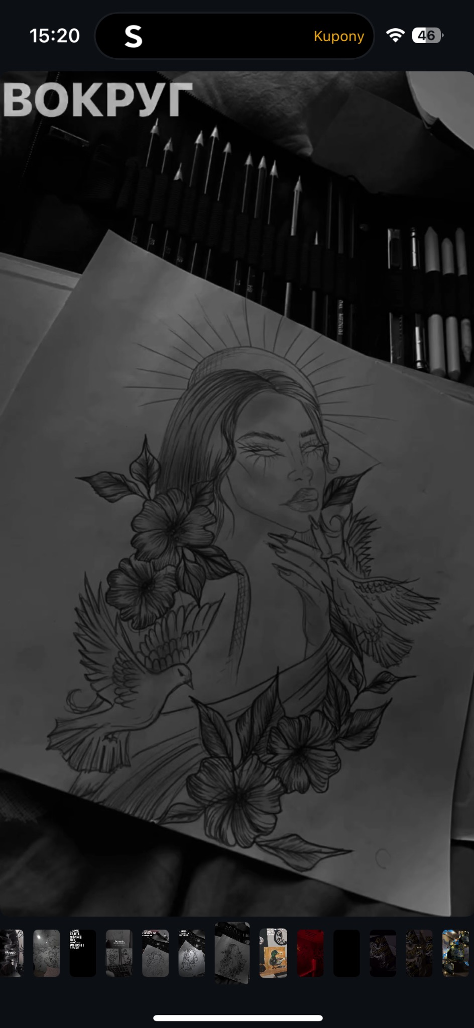 Szkic ołówkiem: portret kobiety z kwiatami i gołębiami na papierze, otoczony przyborami do rysowania w czerni i bieli. Widok z góry.