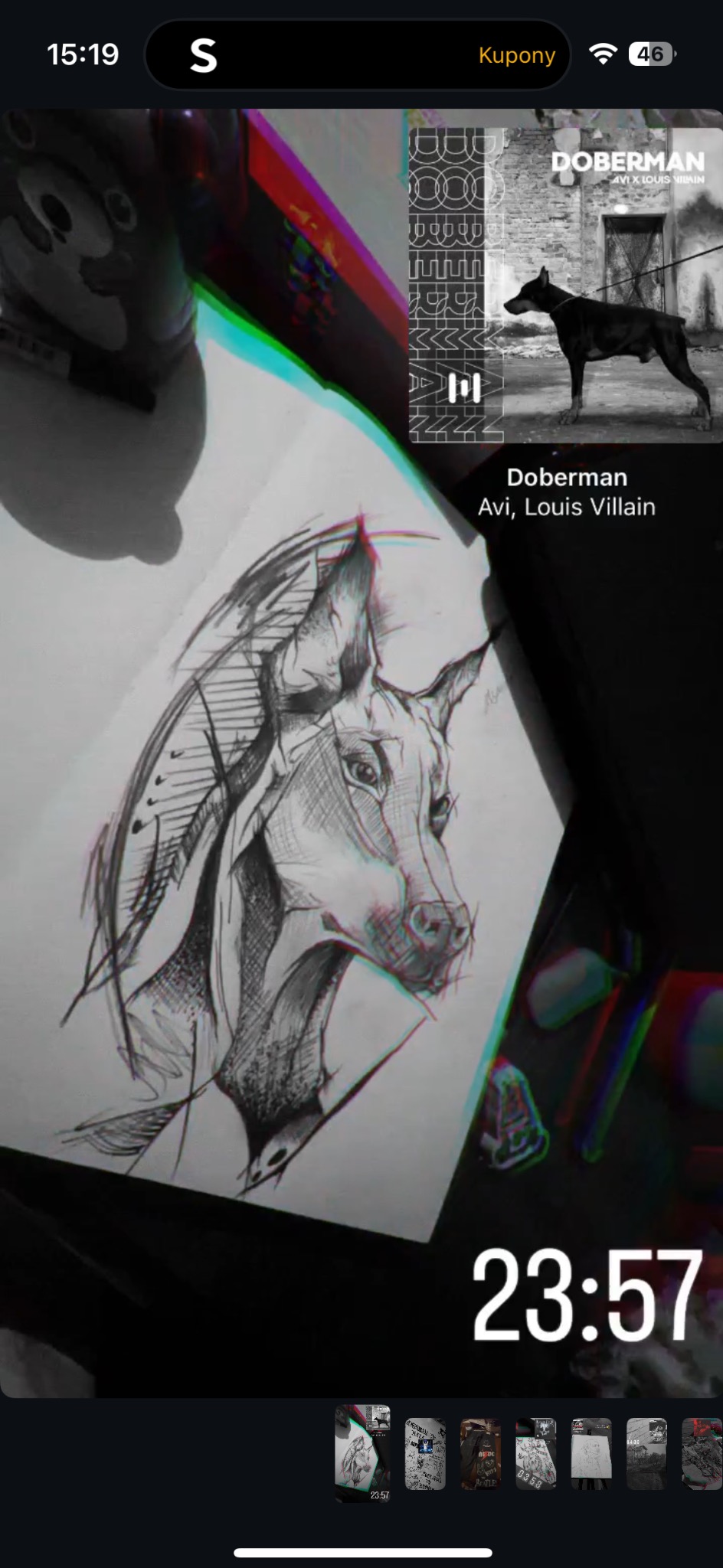 Szkic głowy dobermana na kartce, obok okładka albumu 'Doberman' Avi x Louis Villain, widoczne elementy interfejsu telefonu. Rysunek wykonany czarnym tuszem.