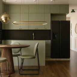 Martitektura Projektowanie i Architektura Wnętrz Marta Bugaj - Nowoczesna kuchnia w odcieniach zieleni z okrągłym stołem i złotymi lampami. Minimalistyczny design, drewniana podłoga i czarna lodówka.