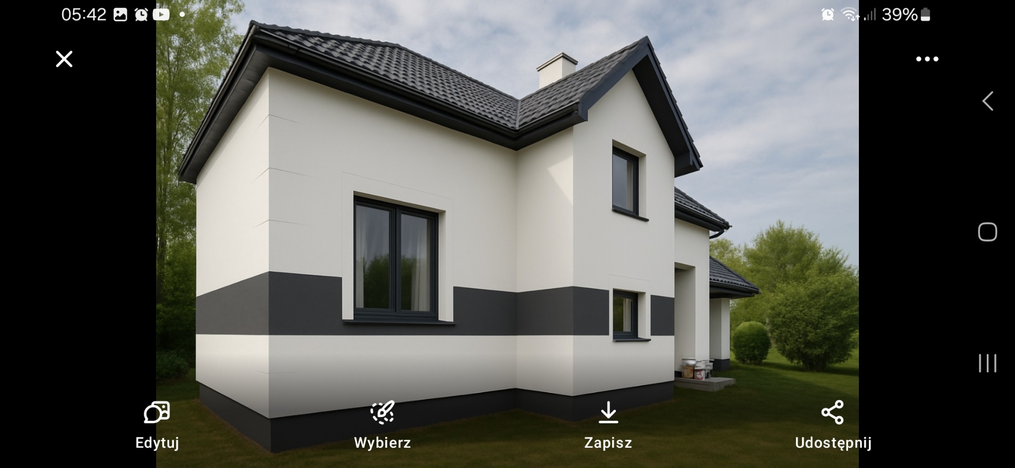 Elewacja domu w kolorze białym z szarym pasem, czarna dachówka, ciemne ramy okien. Widok z boku, na trawniku widoczne puszki po farbie. Dom po remoncie.