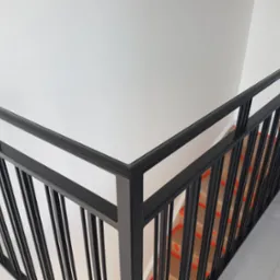 Nowoczesna, czarna balustrada metalowa przy schodach w Kotlin. Minimalistyczny design, gładkie wykończenie, widok z góry. Element wystroju wnętrza.