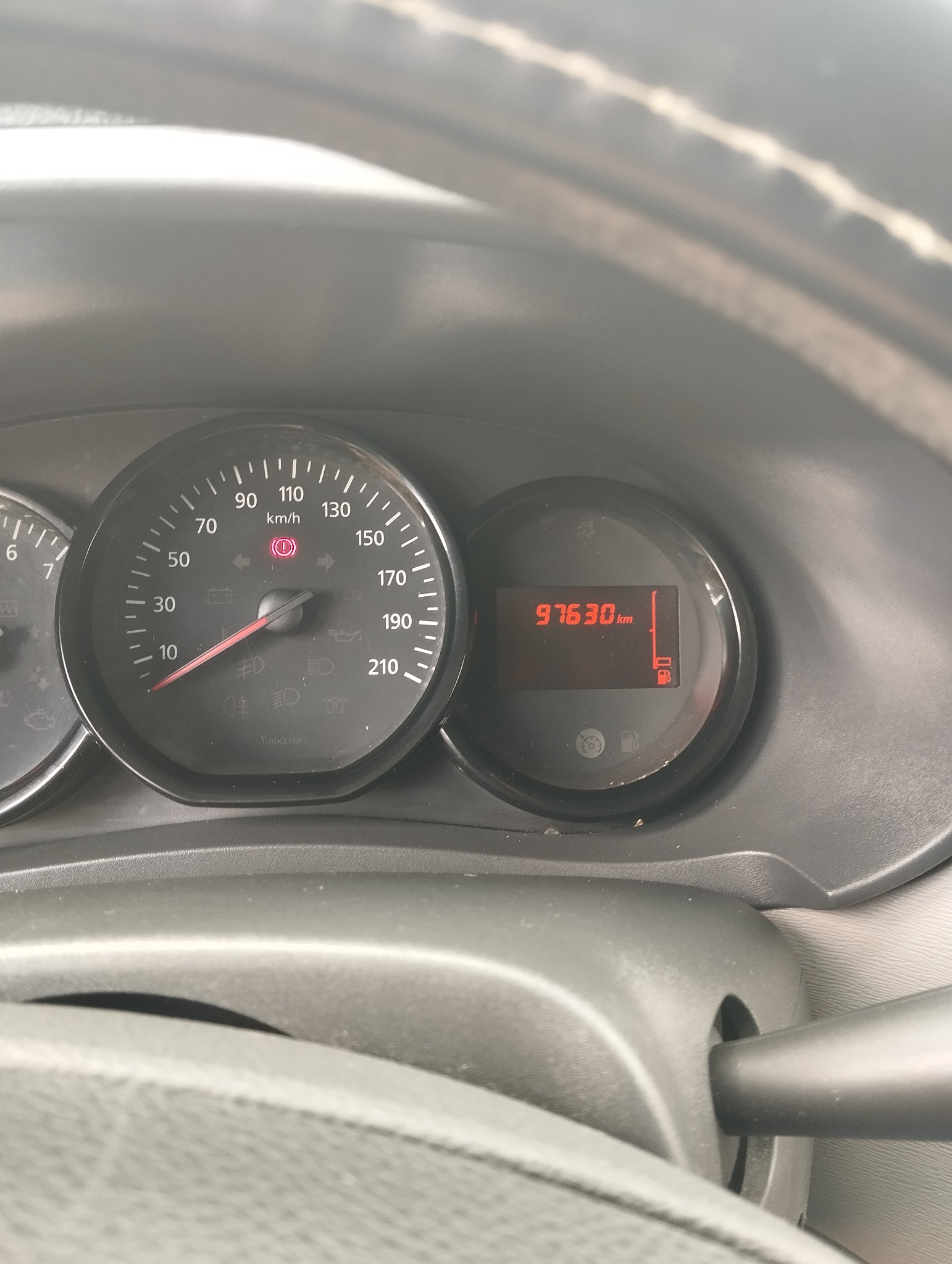 Licznik kilometrów busa z przebiegiem 97630 km, używanego do transportu w Łodzi. Widoczny wskaźnik paliwa i prędkościomierz. Detal deski rozdzielczej.