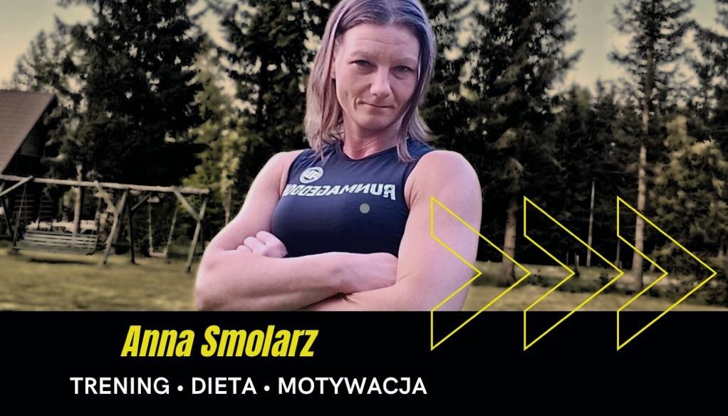 Uśmiechnięta kobieta w sportowym stroju z założonymi rękami, na tle zieleni i huśtawki. Widoczny napis: Anna Smolarz, trening, dieta, motywacja.