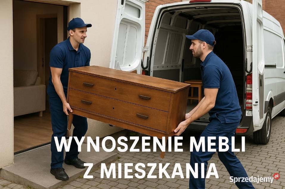 Dwóch mężczyzn w granatowych uniformach wnosi drewnianą komodę do białego busa. Widoczne wnętrze mieszkania i fragment chodnika.