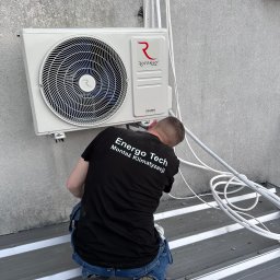 Energo-Tech Bednarczyk - Montaż klimatyzacji Rotenso Ukura Series przez montera Energo Tech na zewnątrz budynku, widoczne przewody i narzędzia na metalowym dachu.