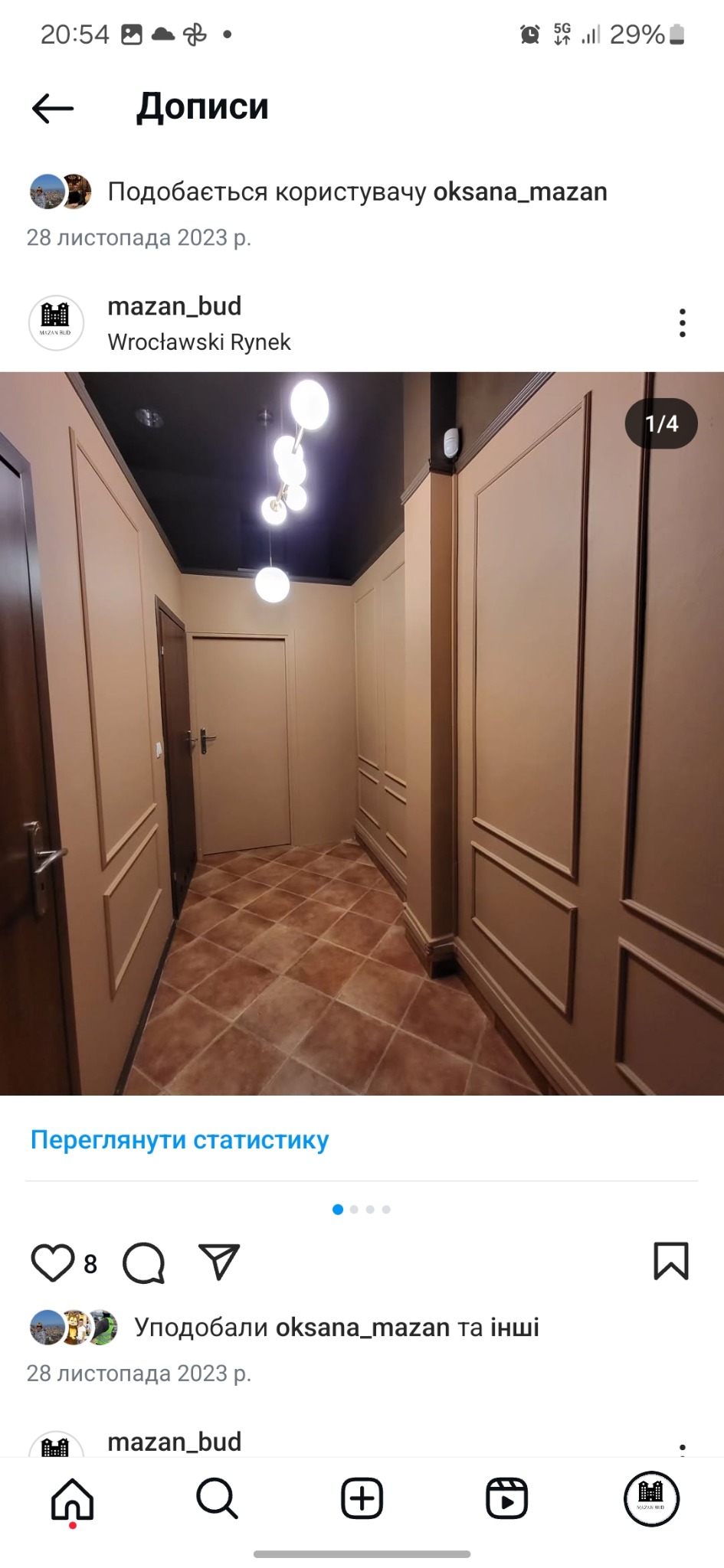 Korytarz po remoncie: beżowe ściany z dekoracyjnymi listwami, brązowa podłoga z płytek ułożonych w karo, czarny sufit z nowoczesną lampą.