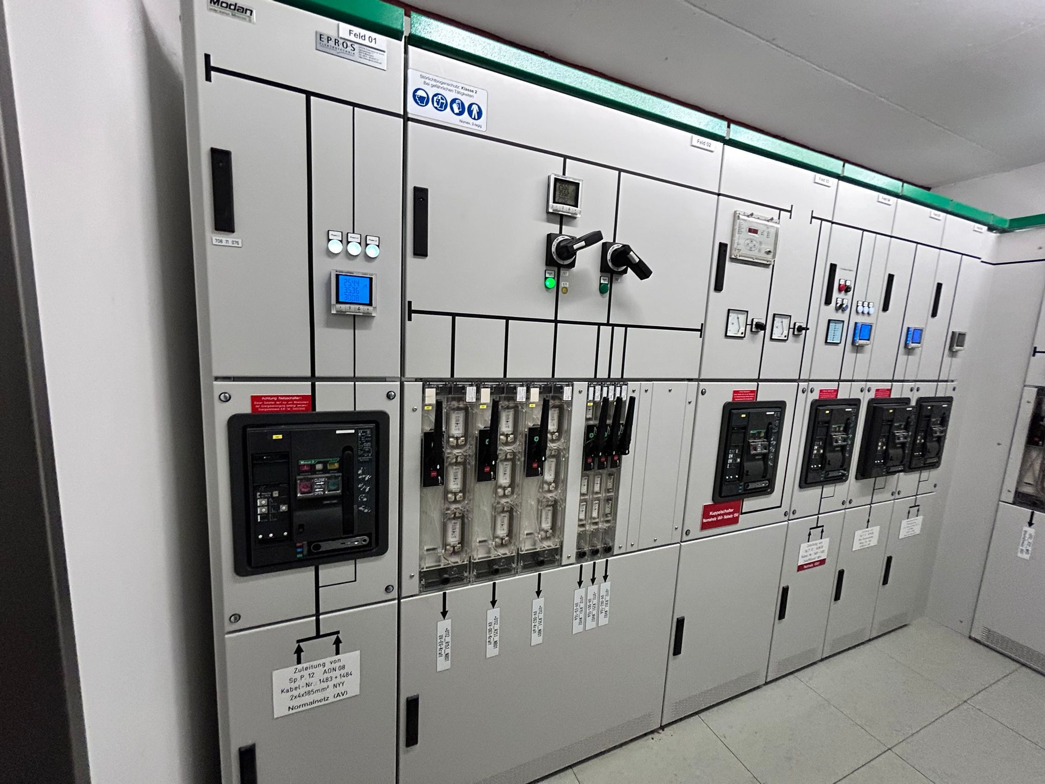 Rozbudowana rozdzielnica elektryczna z licznymi zabezpieczeniami, wskaźnikami i przełącznikami, prezentująca zaawansowaną instalację elektryczną w obiekcie.