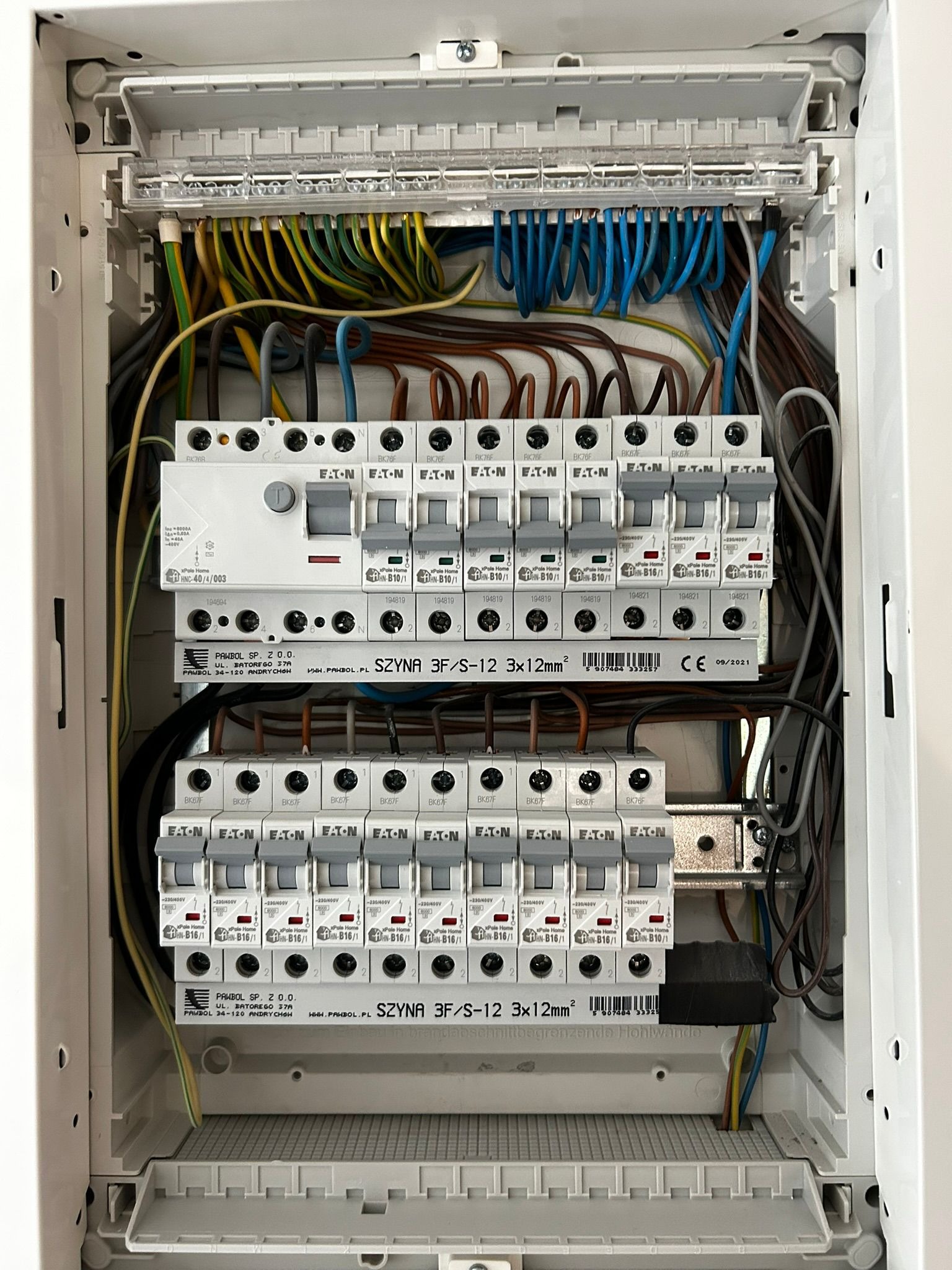 Rozdzielnica elektryczna z bezpiecznikami Eaton i przewodami w Pietrzykowicach. Instalacja po montażu, widok z bliska na układ zabezpieczeń i okablowanie.