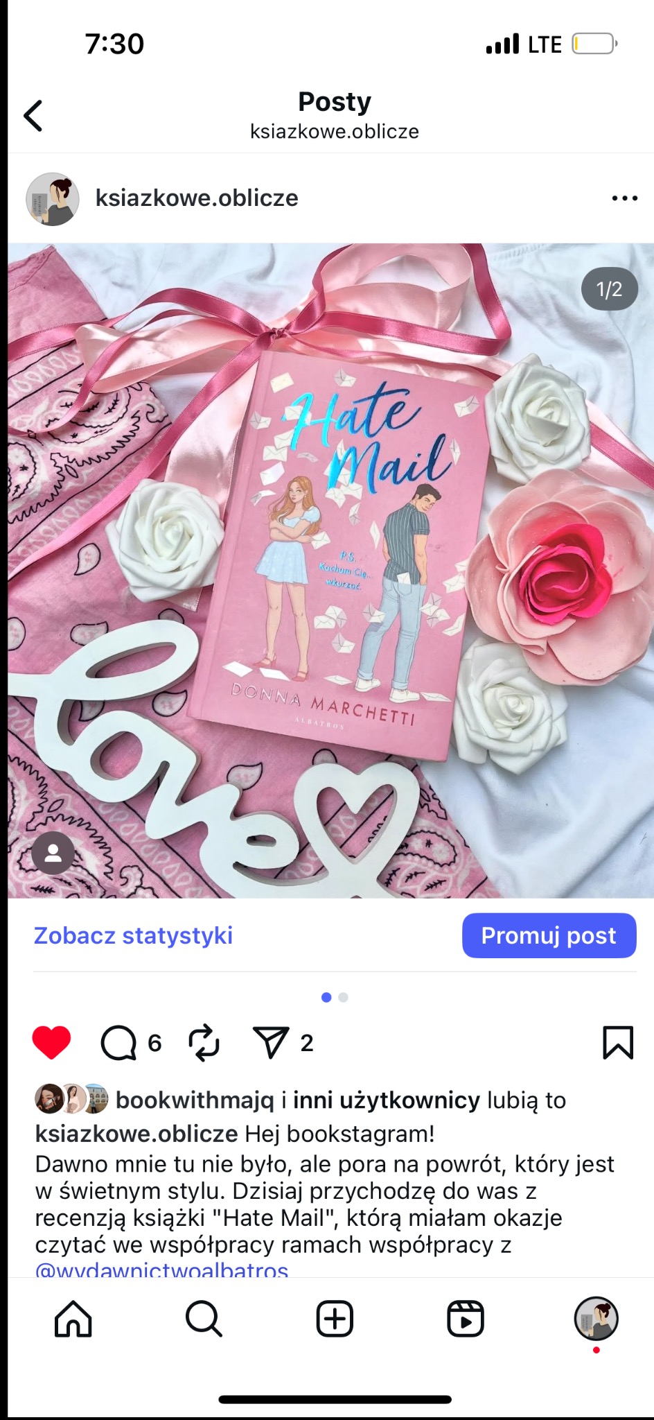 Różowa okładka książki 'Hate Mail' otoczona wstążką, kwiatami i napisem 'love' na tle wzorzystej chusty. Romantyczna kompozycja promująca lekturę.