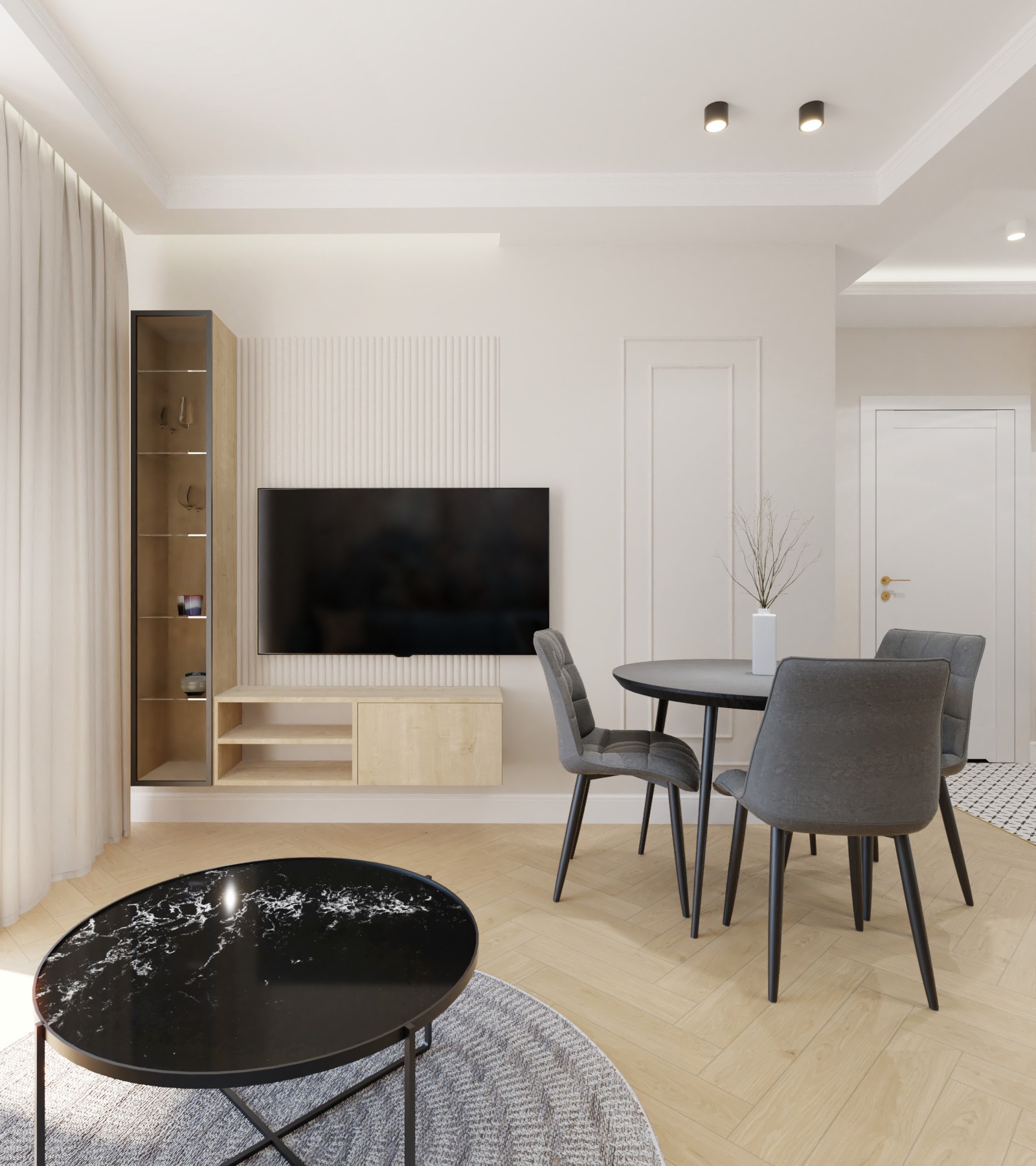 Nowoczesny salon z czarnym stolikiem kawowym i okrągłym stołem jadalnym z szarymi krzesłami. Telewizor na ścianie z dekoracyjnymi panelami. Jasna podłoga i subtelne oświetlenie.