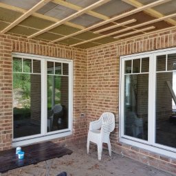 HOLZMET SPÓŁKA CYWILNA SŁAWOMIR MAŚLANY, MATEUSZ MAŚLANY - Montaż okien PCV w nowym budynku z cegły. Widoczne ocieplenie sufitu i białe ramy okienne.