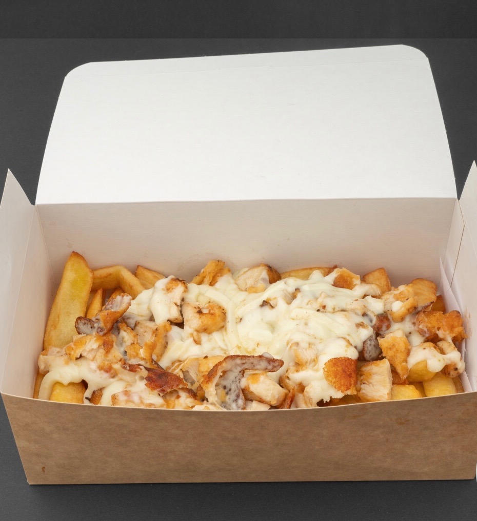 Frytki z kurczakiem i sosem serowym w otwartym kartonowym pudełku na ciemnym tle. Widok z góry.