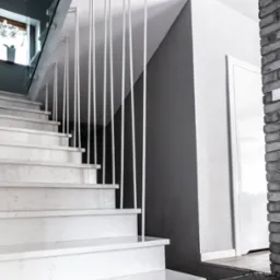 Nowoczesne schody z balustradą szklaną i metalowymi słupkami w Cienin Zaborny-Parcele. Marmurowe stopnie i minimalistyczny design.
