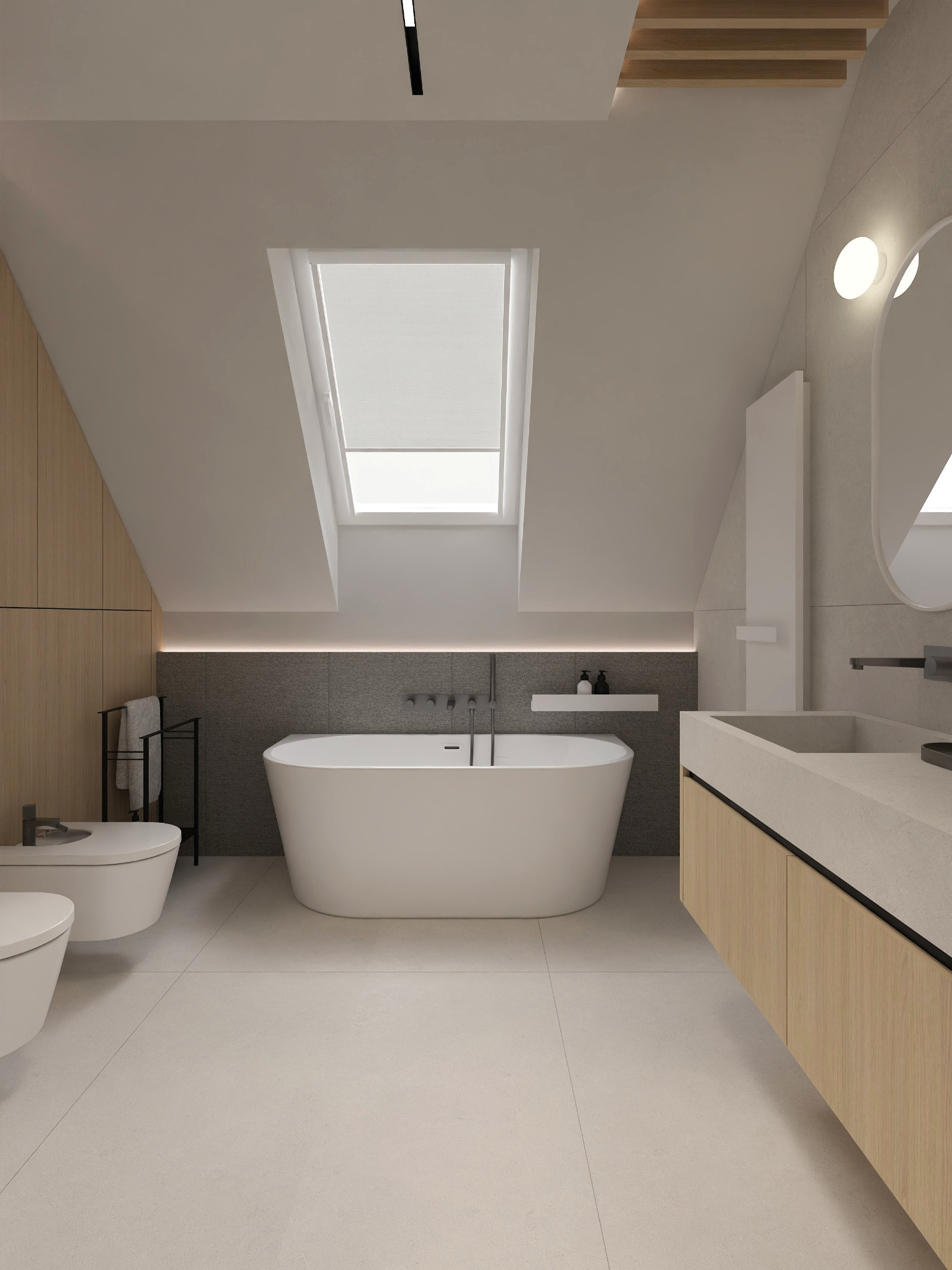 Jasna łazienka na poddaszu z oknem dachowym, wolnostojącą wanną, umywalką z szafką i toaletą. Minimalistyczny design, drewniane akcenty, szare płytki.