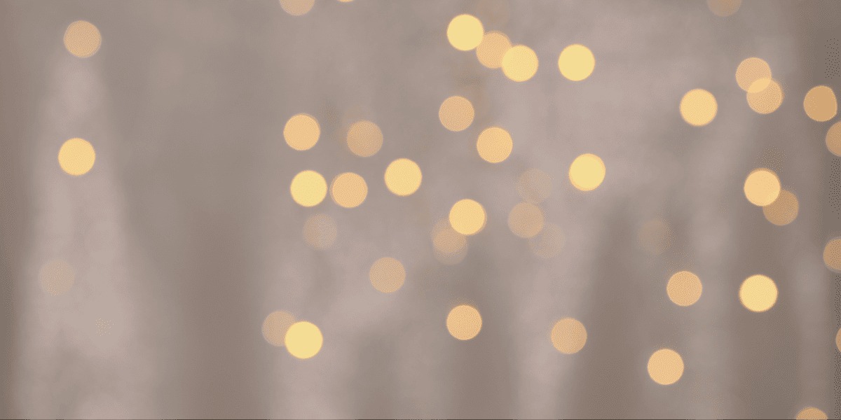 Rozmyte, ciepłe światła bokeh na delikatnym, beżowym tle. Idealne do subtelnych projektów graficznych i wizualizacji świątecznych.