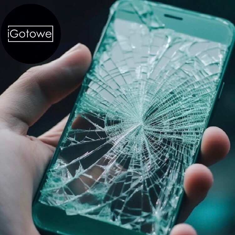 Dłoń trzyma smartfon z pękniętym ekranem, na którym widoczny jest wzór pajęczyny. Uszkodzony wyświetlacz telefonu.